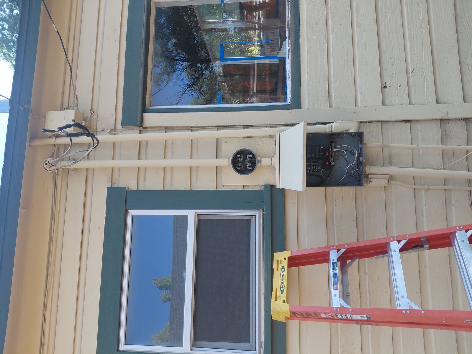 Exterior electrical panel and conduit installed beside a home in Northern Arizona.