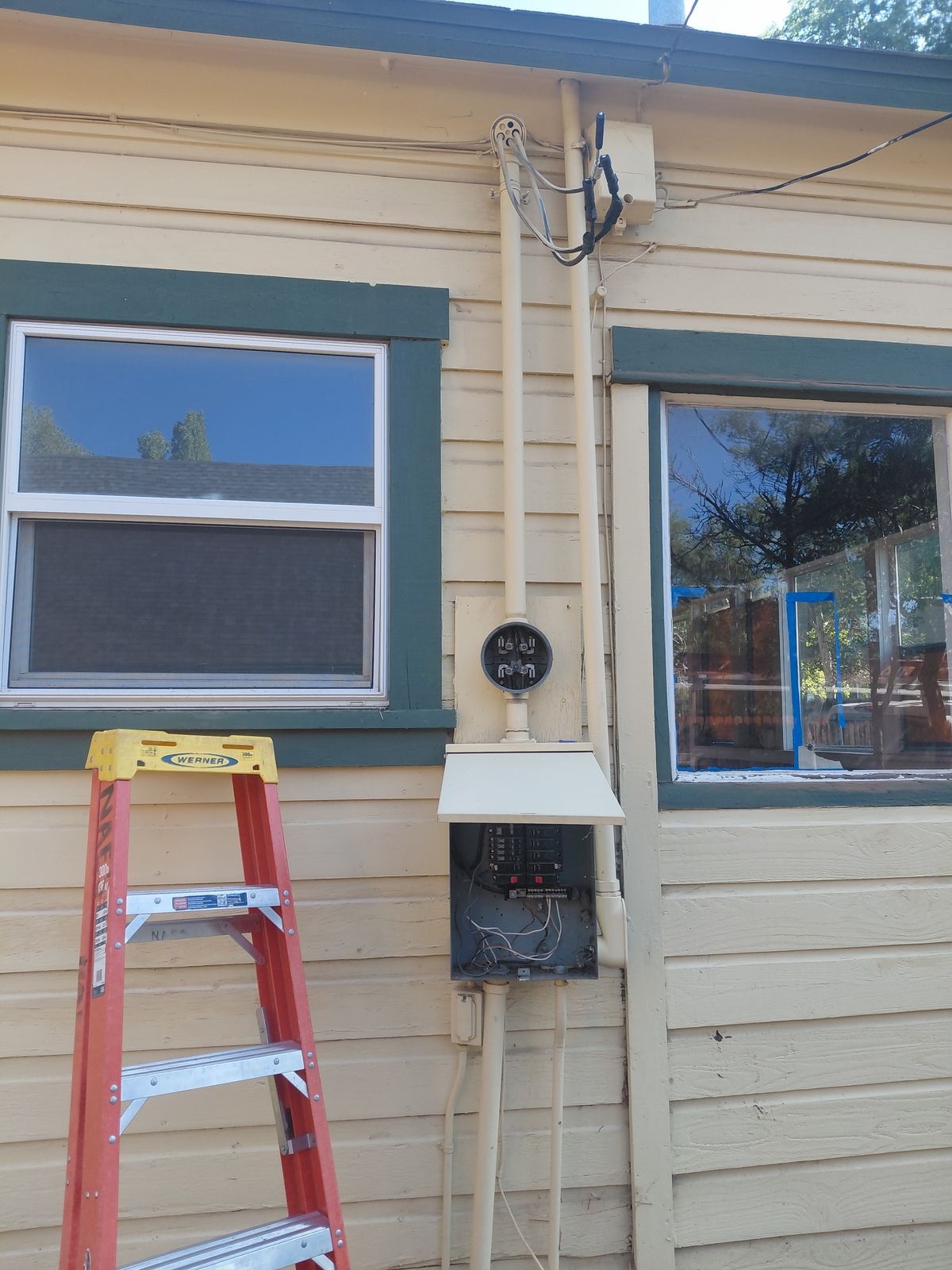 Exterior electrical panel and conduit installed beside a home in Northern Arizona.